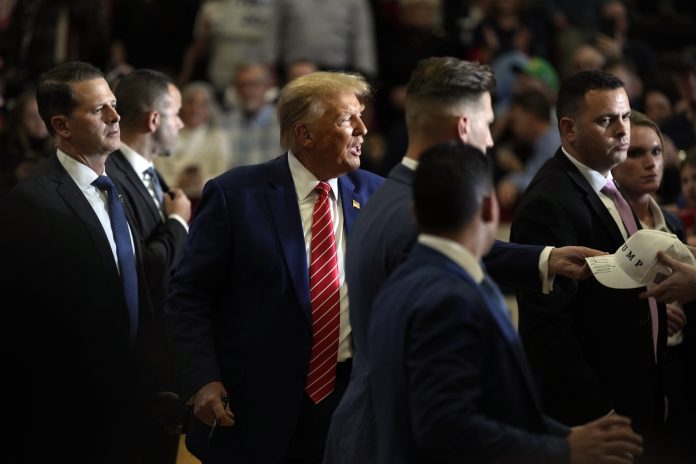 Republican presidential candidate former President Donald Trump signs autographs after speaking during a commit to caucus rally, Saturday, Jan. 6, 2024, in Clinton, Iowa.