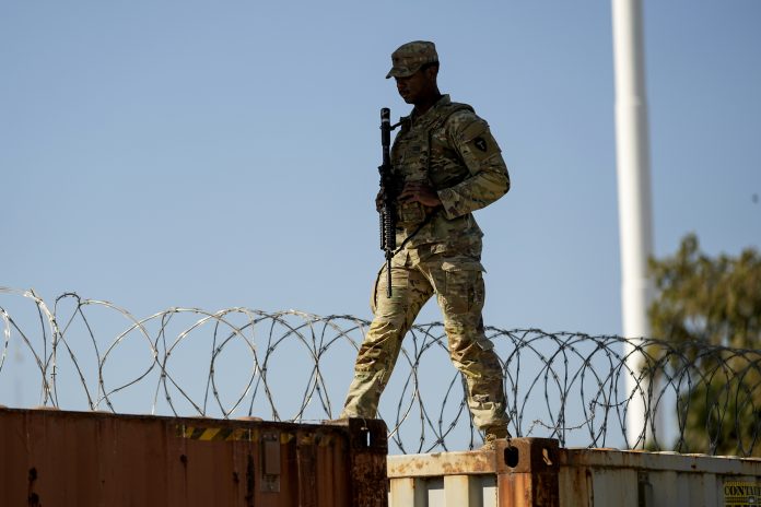 A guardsman walks over rail cars with Concertina wire along the Texas-Mexico border, Jan. 3, 2024, in Eagle Pass, Texas. Senate negotiators were trying to close on a bipartisan border security proposal Monday, Jan. 8, that could unlock Senate Republican support for Ukraine aid. But as Congress returns, House conservatives are trying to interject their own hardline immigration demands.