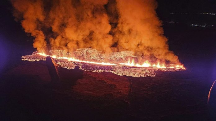 A volcano erupts in southwestern Iceland, sending lava flowing toward a nearby settlement