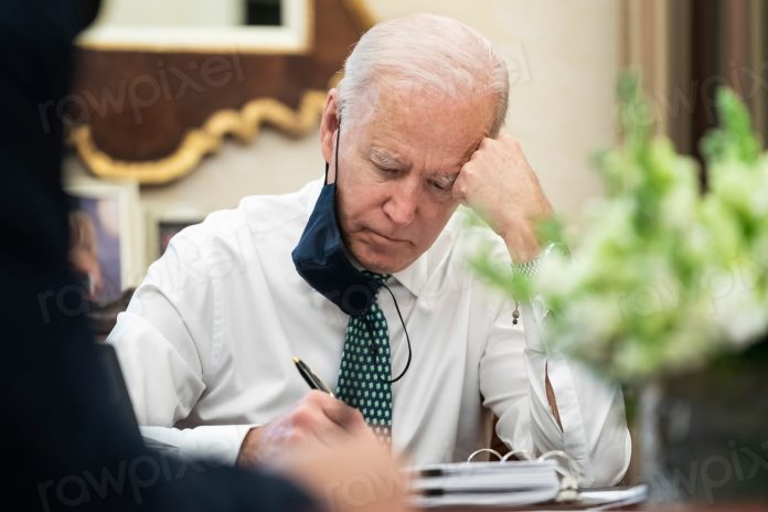 President Joe Biden takes notes