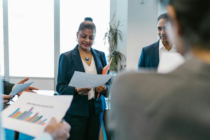 woman in a blazer holding white printer paper