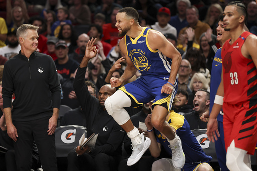 Stephen Curry (30) reacts after scoring a basket against the Portland Trail Blazers during the second half of an NBA basketball game Wednesday, Oct. 23, 2024, in Portland, Ore. (AP Photo/Amanda Loman)