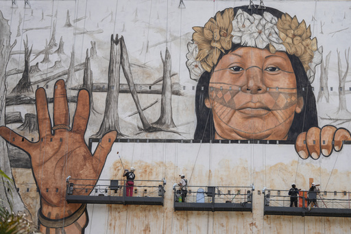 A Brazilian muralist employs ash and soil to create a large-scale artwork in Sao Paulo addressing climate-related tragedies.