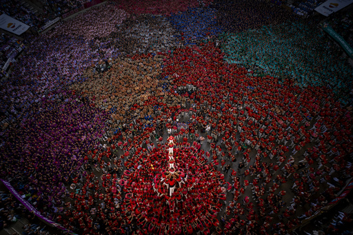 An AP photographer captures perfect lighting from an elevated viewpoint during a human tower competition.