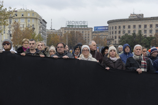 Serbian protesters stage a 15-minute blockade to honor 15 victims of a roof collapse, calling for justice.