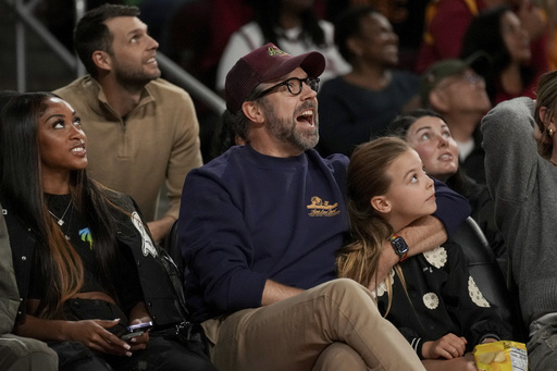 Michael B. Jordan takes a break during women’s college basketball match to autograph a striking photo.