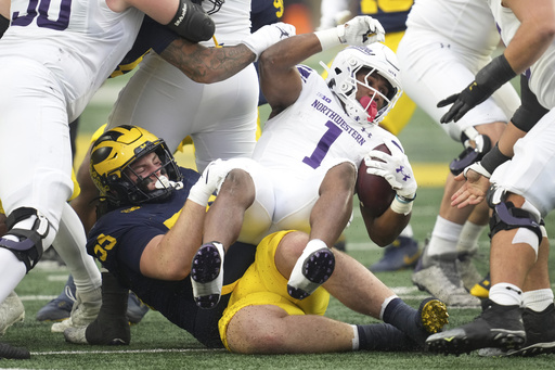 Kalel Mullings scores a personal-best three touchdowns as Michigan secures bowl eligibility with a 50-6 victory over Northwestern.