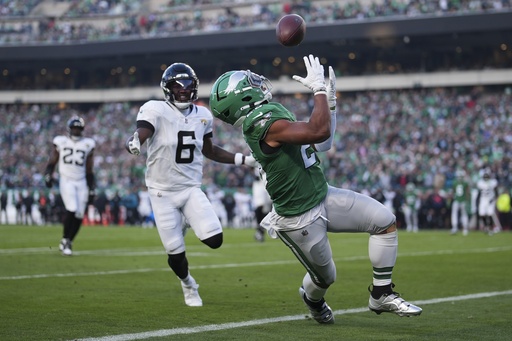 Eagles running back Saquon Barkley stuns fans with impressive backward leap for first down catch.