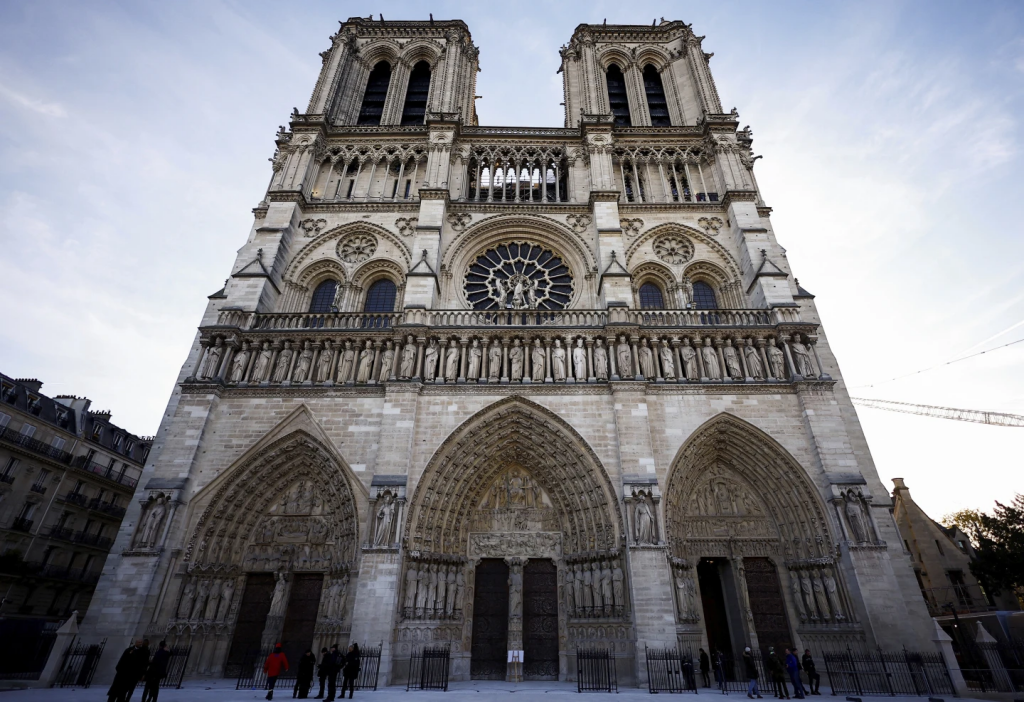 People stand outside Notre-Dame Cathedral in Paris, Friday Nov. 29 2024 before French President Emmanuel Macron’s final visit to the construction site to see the restored interiors before the iconic monument’s reopening for worship on Dec. 8. (Sarah Meyssonnier, Pool via AP)