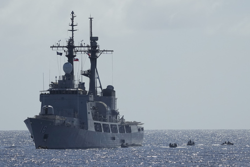 Philippine troops reclaim an island during a simulated battle while monitored by China’s naval forces.