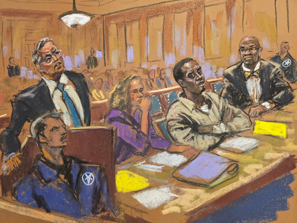 In this courtroom sketch, attorney Marc Agnifolo, left, speaks at the podium, as Alexandra Shapiro, Sean Diddy Combs, and attorney Tony Riccio, seated second left to right, listen during a hearing  in federal court, Friday, Nov. 24, 2024, in New York. (Jane Rosenberg via AP)