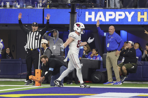 Trey McBride of the Cardinals achieves personal milestones, yet helmet deflection results in defeat.