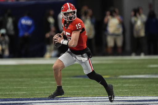 Georgia quarterback Carson Beck suffers blow to throwing arm ahead of halftime, raising concerns about his condition.