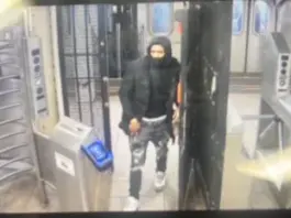 Suspect fled the scene after pushing the victim onto the tracks. Police describe him as light-skinned, masked, wearing a black jacket, hoodie, and gray jeans.