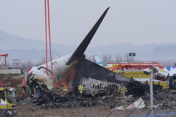 Rescue team members work at the site of a plane fire at Muan International Airport in Muan, South Korea, Monday, Dec. 30, 2024. (AP Photo/Ahn Young-joon)