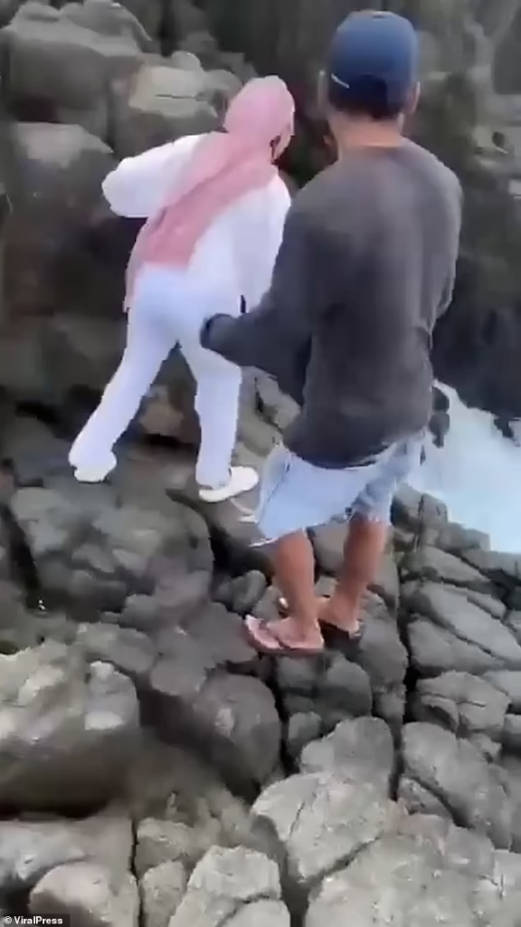 Frantic locals trying to rescue Merlin, seen in the video desperately clinging onto a boulder as the churning waters battered her

