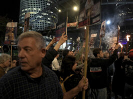 Relatives and friends of people killed and abducted by Hamas and taken into Gaza, react to the ceasefire announcement as they take part in a demonstration in Tel Aviv, Israel, Wednesday, Jan. 15, 2025. (AP Photo/Oded Balilty)