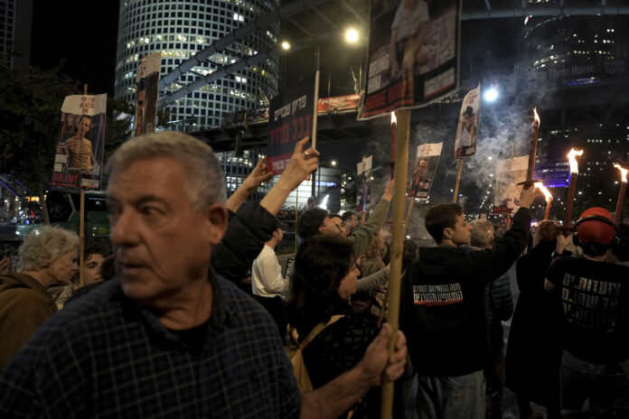 Relatives and friends of people killed and abducted by Hamas and taken into Gaza, react to the ceasefire announcement as they take part in a demonstration in Tel Aviv, Israel, Wednesday, Jan. 15, 2025. (AP Photo/Oded Balilty)