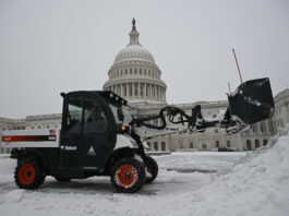 A front end loader clears a heavy early morning snow fall on the east side of the Capitol ahead of a joint session of Congress to certify the votes from the Electoral College in the presidential election, Monday, Jan. 6, 2025, in Washington. (AP Photo/John McDonnell)