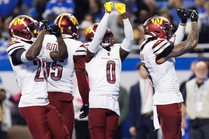 DETROIT, MICHIGAN - JANUARY 18: Cornerback Mike Sainristil #0 of the Washington Commanders celebrates with teammates after an interception during the first half of an NFL football divisional playoff game against the Detroit Lions, at Ford Field on January 18, 2025 in Detroit, Michigan. (Photo by Brooke Sutton/Getty Images)