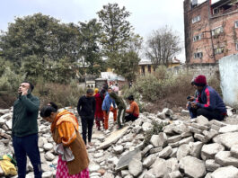 Nepalese people who rushed out of their homes after experiencing an earthquake stand amidst construction material in Kathmandu, Nepal, Tuesday, Jan.7, 2025. (AP Photo/Sunil Sharma)