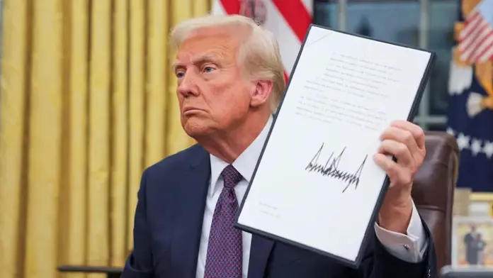 President Donald Trump holds a document on the day he issues executive orders and pardons for Ja. 6 defendants in the Oval Office at the White House in Washington, D.C., on Monday. (Reuters/Carlos Barria)