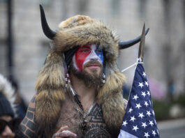 WASHINGTON, DC - JANUARY 06: Jacob Chansley, a.k.a. Jake Angeli and the QAnon Shaman, speaks to passersby during the "Stop the Steal" rally on January 06, 2021 in Washington, DC. Chansley was later charged with knowingly entering a restricted building without lawful authority and disorderly conduct on federal grounds. Trump supporters gathered in the nation's capital today to protest the ratification of President-elect Joe Biden's Electoral College victory over President Trump in the 2020 election.(Photo by Robert Nickelsberg/Getty Images)