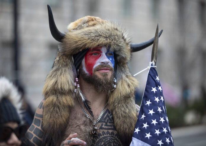 WASHINGTON, DC - JANUARY 06: Jacob Chansley, a.k.a. Jake Angeli and the QAnon Shaman, speaks to passersby during the 