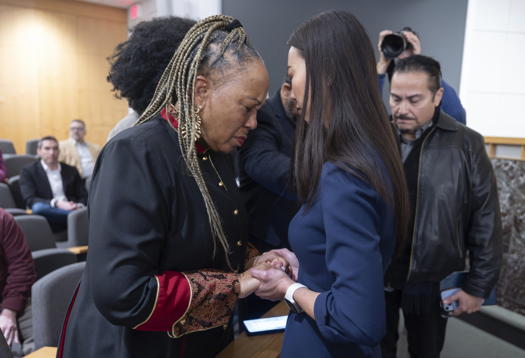 Wichita, Kan., mayor Lily Wu, right, prays with Rev. Pamela Hughes before a prayer vigil in Wichita, Kan., on Thursday, Jan. 30, 2025, for those affected by the crash of American Airlines flight 5342 near Washington the day before. (AP Photo/Travis Heying)