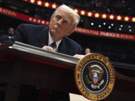 President Donald Trump signs an executive order as he attends an indoor Presidential Inauguration parade event at Capital One Arena, Monday, Jan. 20, 2025, in Washington. (AP Photo/Evan Vucci)