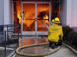 Firefighters aim a hose at the entrance to a Bank of America engulfed in flames on Lake Avenue, Wednesday, Jan. 8, 2025, in the Altadena section of Pasadena, Calif. (AP Photo/Chris Pizzello)