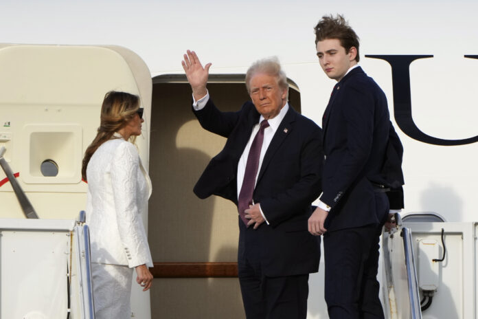 President-elect Donald Trump, standing with Melania and Barron Trump, waves as they board an Air Force Special Mission airplane at Palm Beach International Airport Saturday, Jan. 18, 2025 in West Palm Beach, Fla., enroute to Washington. (AP Photo/Lynne Sladky)(AP Photo/Lynne Sladky)