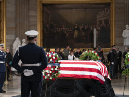 Mourners look at the flag-draped casket of former President Jimmy Carter as he lies in state in the Capitol, Tuesday, Jan. 7, 2025, in Washington. Carter died Dec. 29 at the age of 100. (AP Photo/Jose Luis Magana)