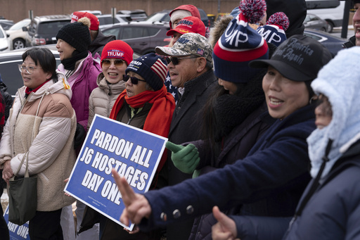 Supporters of President Donald Trump stand with their flags in support of people convicted for their part in the Jan. 6 riot at the U.S. Capitol at the DC Central Detention Facility in Washington, Tuesday, Jan. 21, 2025. (AP Photo/Jose Luis Magana)