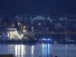 A Coast Guard vessel with a crane works near the wreckage of a Black Hawk helicopter in the Potomac River from Ronald Reagan Washington National Airport, Friday, Jan. 31, 2025, in Arlington, Va. (AP Photo/Alex Brandon)