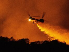 A helicopter drops water on the Palisades Fire in Mandeville Canyon, Saturday, Jan. 11, 2025, in Los Angeles.(AP Photo/Etienne Laurent)