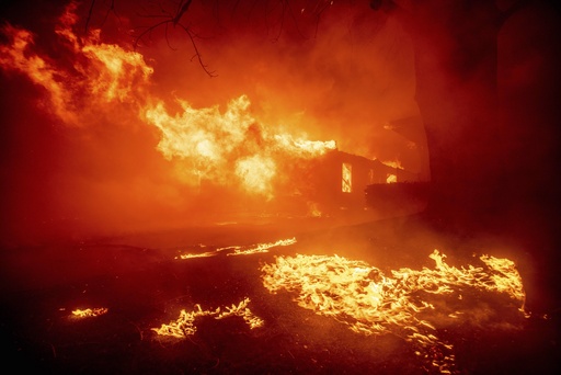 FILE - The Eaton Fire destroys a structure, Jan. 7, 2025, in Altadena, Calif. (AP Photo/Ethan Swope, File)