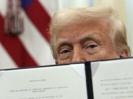 President Donald Trump holds up a signed executive order regarding cryptocurrency in the Oval Office of the White House, Thursday, Jan. 23, 2025, in Washington. (AP Photo/Ben Curtis)