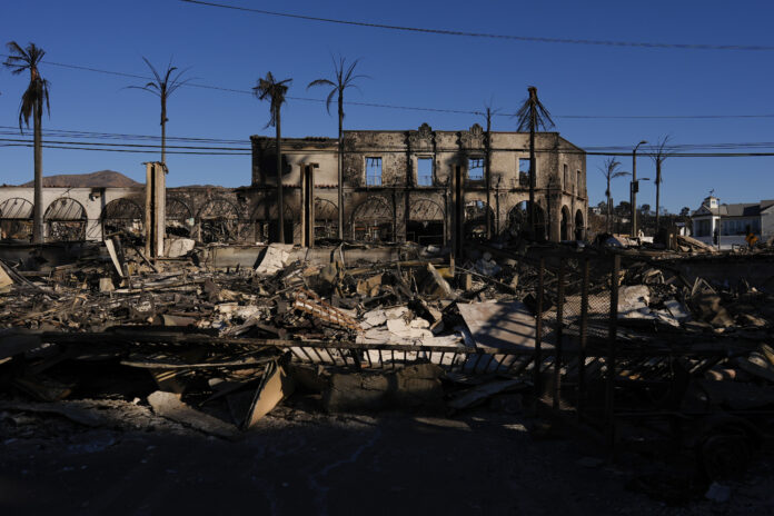 Burned businesses are left behind by the Palisades Fire in the Pacific Palisades neighborhood of Los Angeles, Tuesday, Jan. 14, 2025. (AP Photo/Carolyn Kaster)