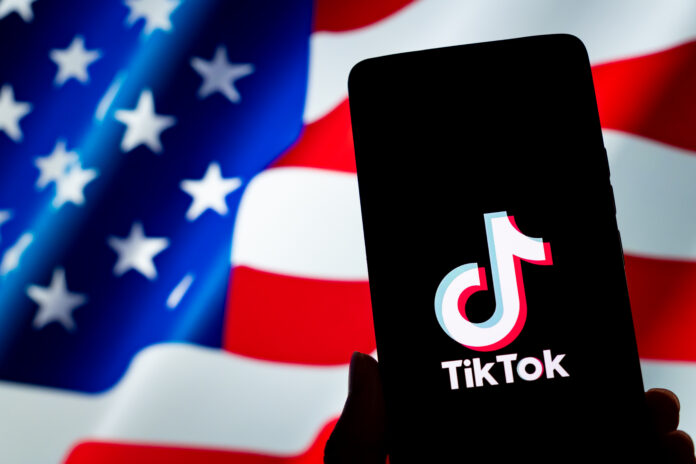 CHONGQING, CHINA - JANUARY 9, 2025 - A TikTok logo is displayed on a smartphone with the U.S. flag in the background in Chongqing, China, Jan. 9, 2025. (Photo credit should read CFOTO/Future Publishing via Getty Images)