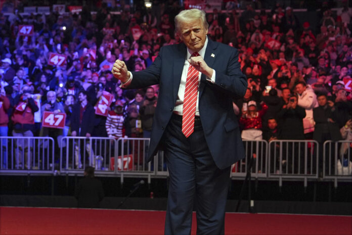 President-elect Donald Trump dances with The Village People at a rally ahead of the 60th Presidential Inauguration, Sunday, Jan. 19, 2025, in Washington. (AP Photo/Evan Vucci)