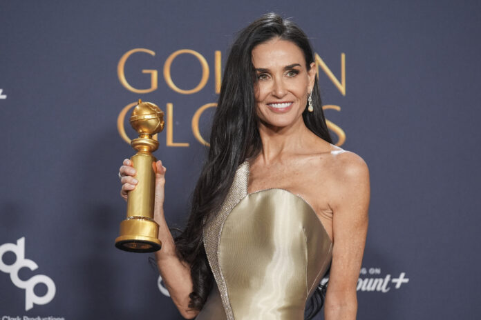 Demi Moore poses in the press room with the award for best performance by a female actor in a motion picture - musical or comedy for 