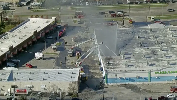 Firefighters spray water on the Plaza Latina shopping center in Dallas, Texas on Friday. (KDFW)

