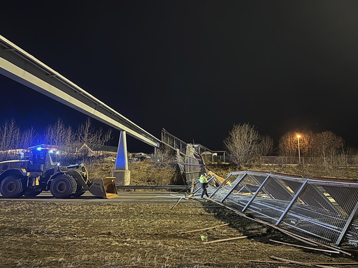 Strong winds cause fencing and roof of Anchorage pedestrian bridge to collapse, shutting down highway.