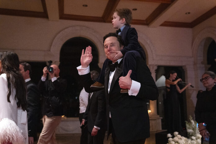 Elon Musk and his son, X AE A-Xii, arrive to a New Year's Eve party hosted by President-elect Donald Trump at Mar-a-Lago, Tuesday, Dec. 31, 2024, in Palm Beach, Fla. (AP Photo/Evan Vucci)