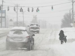 FILE - Heavy snow falls as a person walks along U.S. Route 42 in Florence, Ky., Monday, Jan. 6, 2025. (AP Photo/Carolyn Kaster, File)