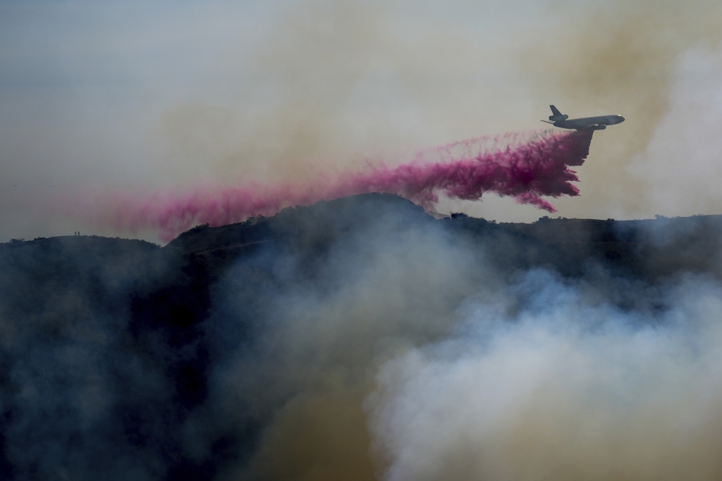 FILE - Fire retardant is dropped by an air tanker on the Palisades Fire in the outskirts of the Pacific Palisades neighborhood of Los Angeles, Jan. 10, 2025. (AP Photo/Eric Thayer, File)