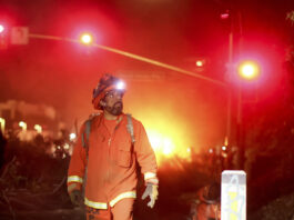 A California Department of Corrections hand crew works containment lines ahead of the Palisades Fire Tuesday, Jan. 14, 2025 in Santa Monica, Calif. (AP Photo/Ethan Swope)