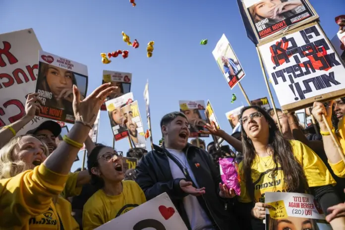 People react as they watch broadcast of the release of Israeli soldier Agam Berger, one of eight hostages set to be released today as part of a ceasefire in the Gaza Strip, in Tel Aviv, Israel, Thursday, Jan. 30, 2025. (AP Photo/Oded Balilty)