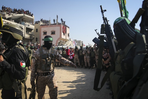 Hamas and Islamic Jihad militants secure the area as Red Cross representatives wait for the handover of Thai and Israeli hostages in Khan Younis, southern Gaza Strip, Thursday Jan. 30, 2025.(AP Photo/Jehad Alshrafi)